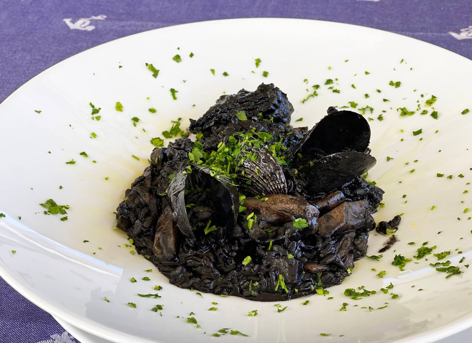 Risotto al nero di seppia con cozze e prezzemolo.